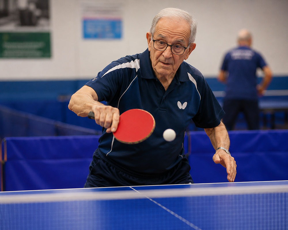 Señor jugando al tenis de mesa